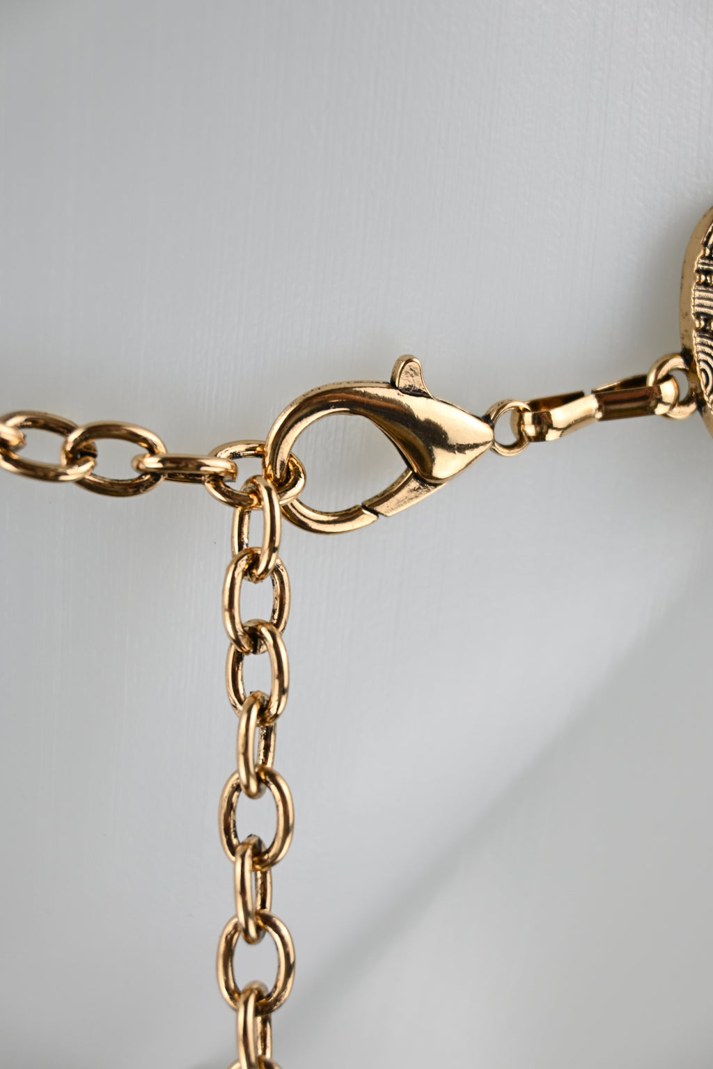 Cintura gioiello a placche alternate con borchie, medaglioni metallici e catena regolabile