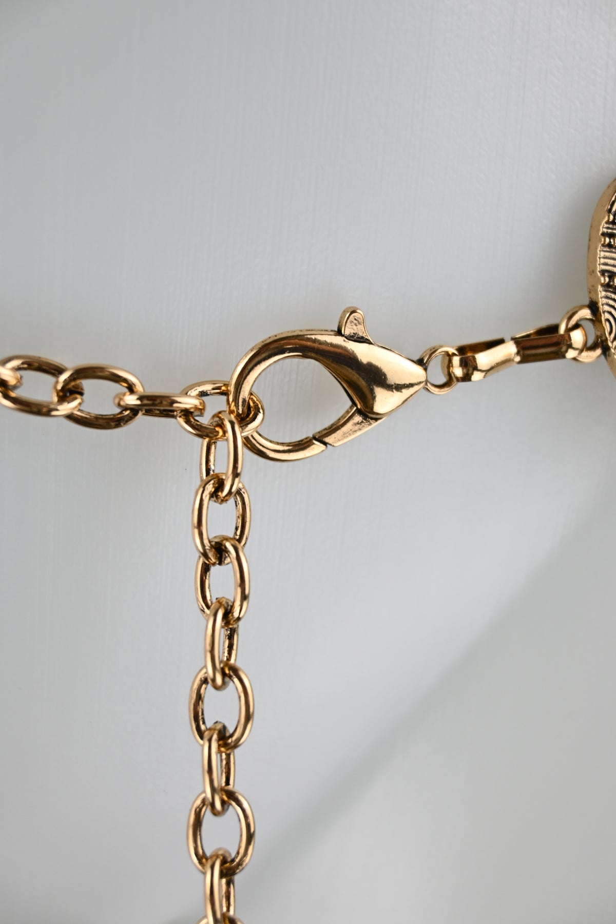 Cintura gioiello a placche alternate con borchie, medaglioni metallici e catena regolabile